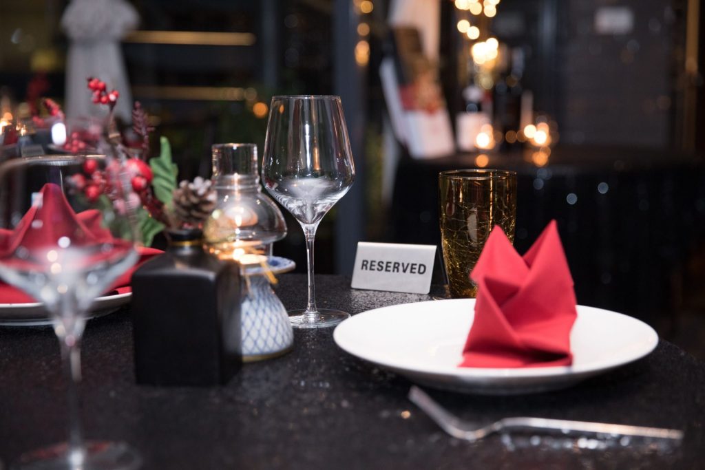 Cozy restaurant table setting with reserved sign and festive decor.