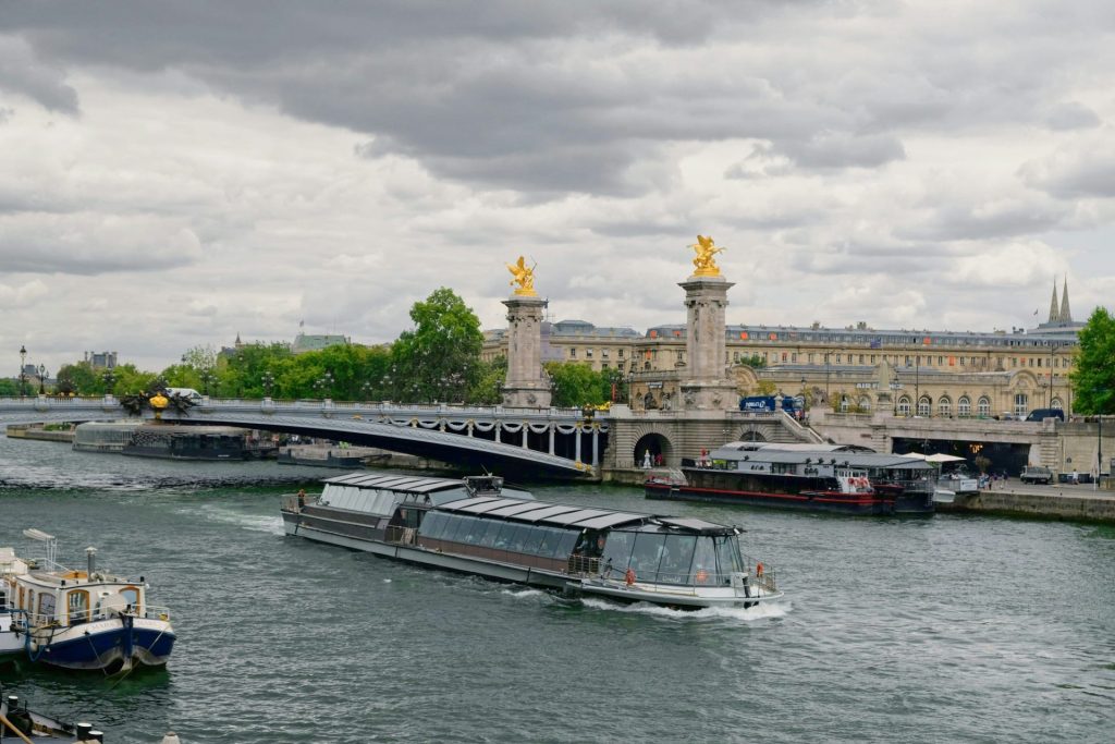 Boats on the seine river with pont alexandre iii bridge