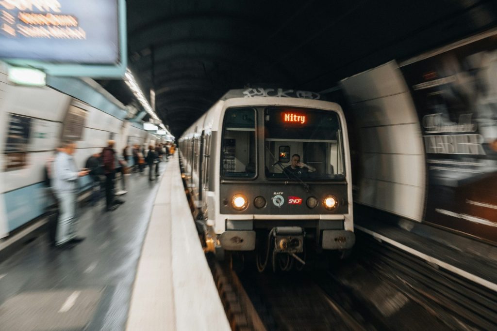 a train traveling through a train station next to a crowd of people